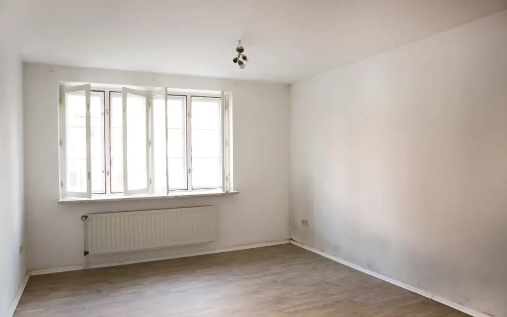 Discolored patches of mould on a wall near a window